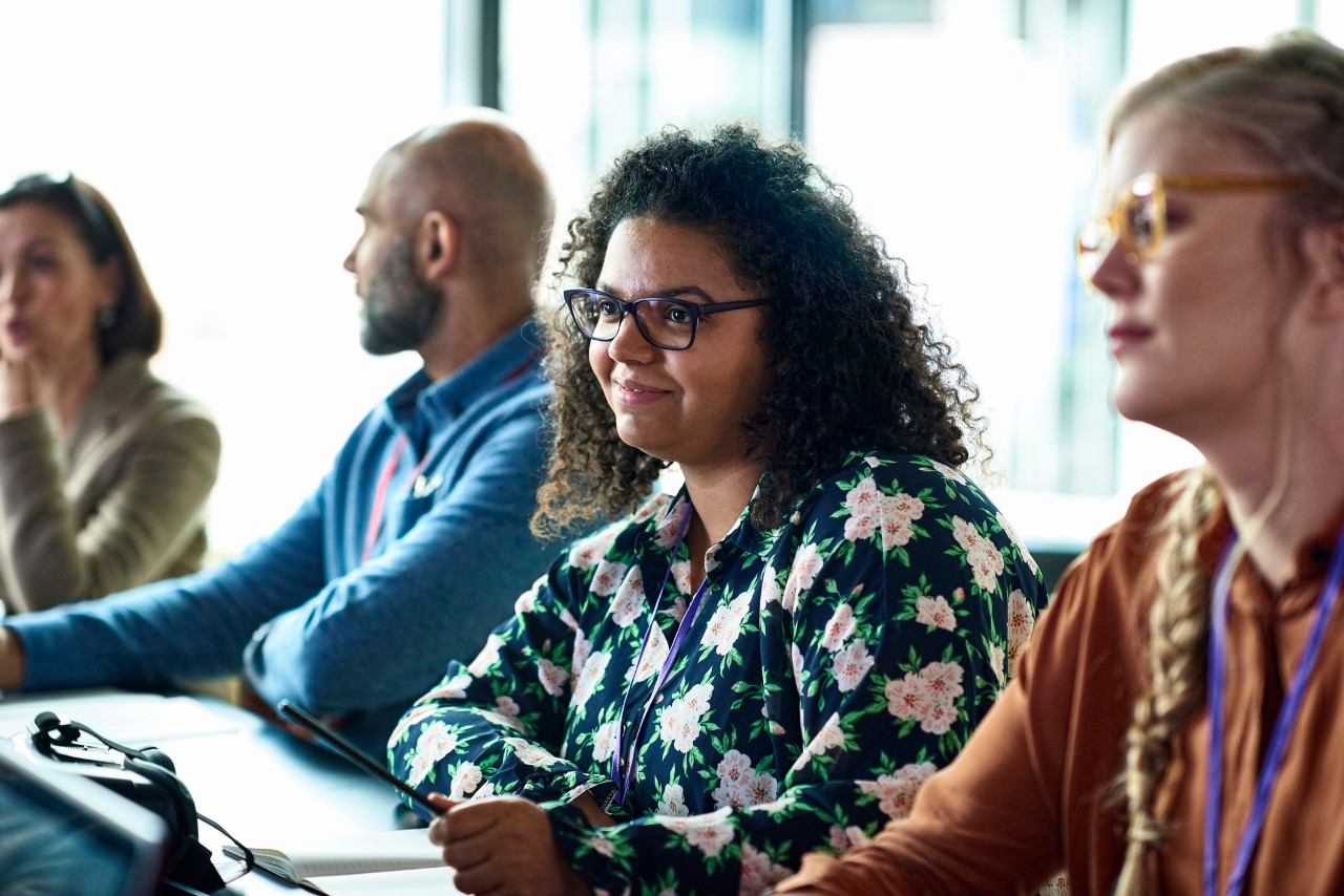 Smiling woman sitting at conference table during business meeting