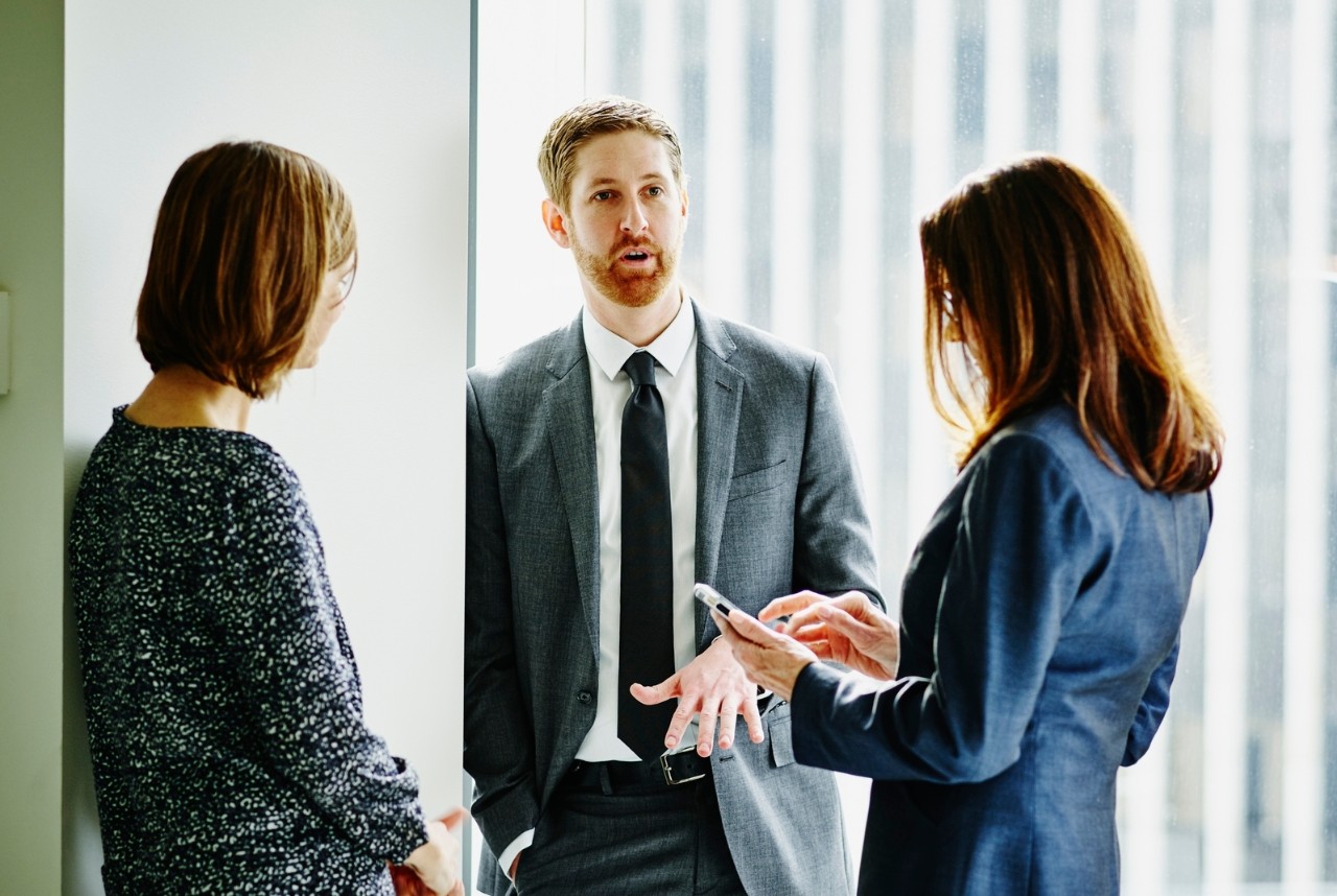 Businessman in discussion with businesswomen during informal meeting in office