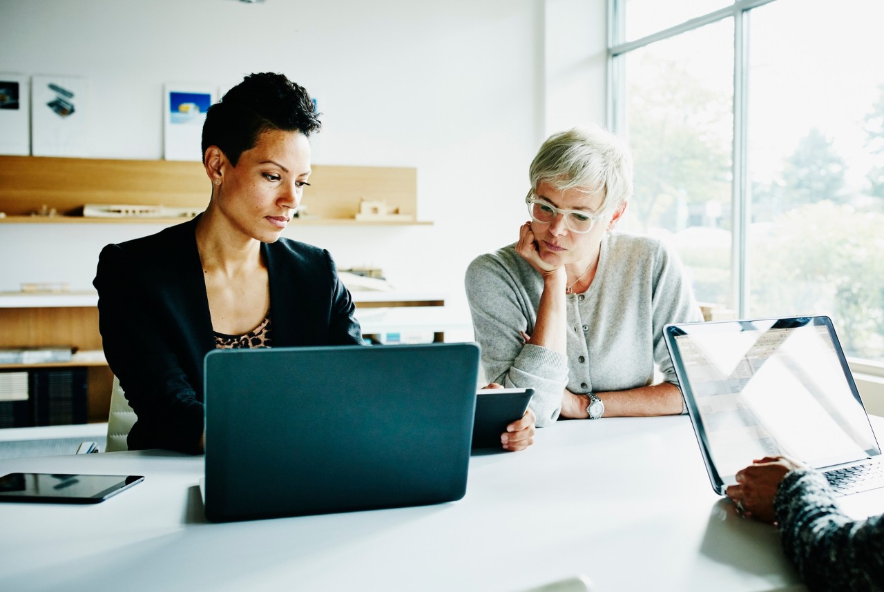 Three businesswomen discussing project during meeting in office